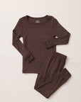 A two-piece children's pajama set in dark brown, featuring a long-sleeve top with rolled cuffs and matching pants with elastic waistband and leg cuffs, laid flat on a light beige background.