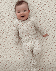 Baby lying on a strawberry patterned surface wearing a matching outfit. @ashleylapido