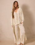 Woman wearing a matching strawberry robe and sleep set outfit against a beige background