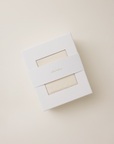 White box with a cream pointelle fabric inside on a beige background