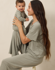 Woman in matching mist pointelle sleep sets holding a baby against a plain background