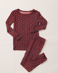 A two-piece long-sleeve pajama set laid flat on a light beige background. The set features a dark red top and matching pants with a small, repeating red and pink floral pattern.
