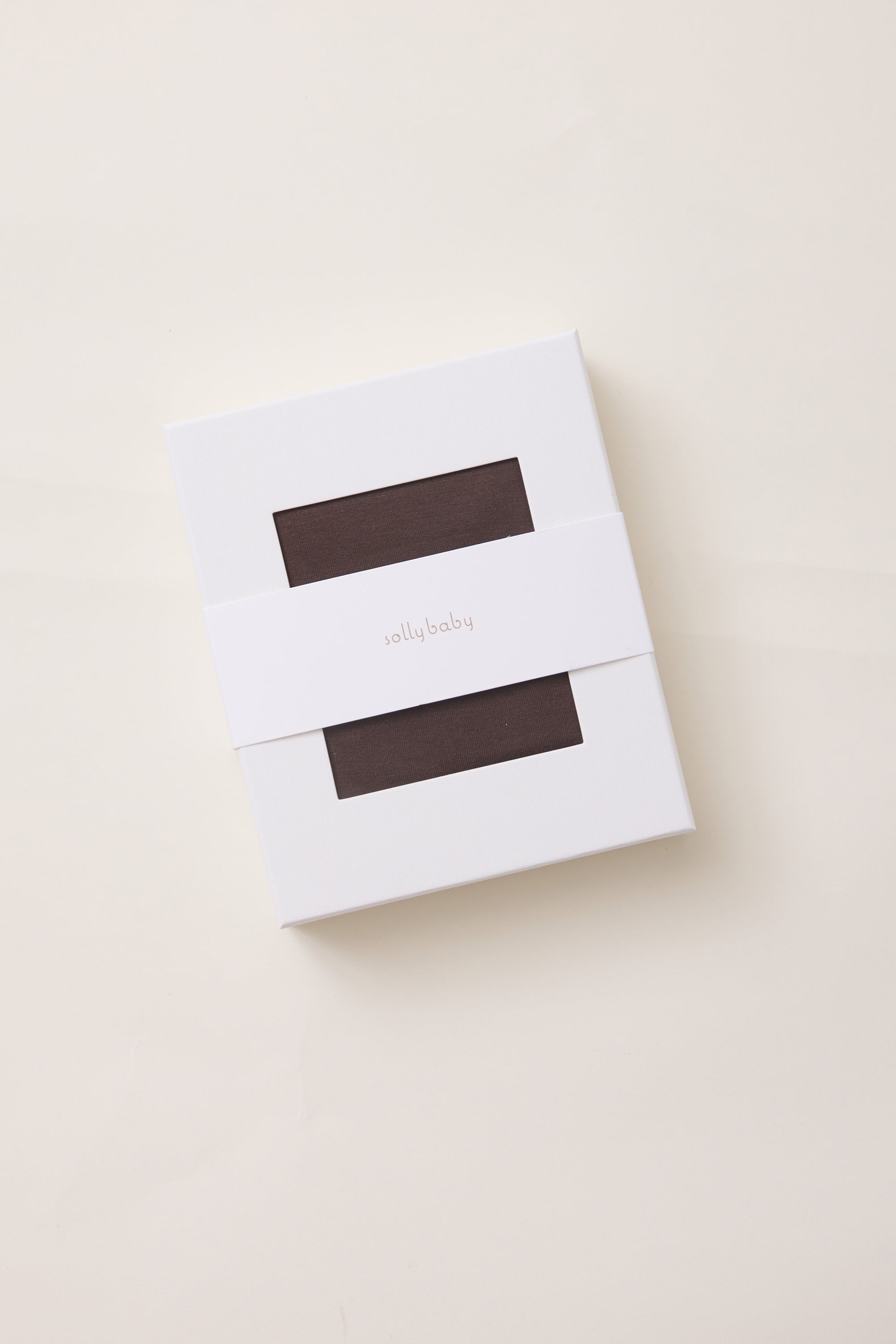 White box on white background. Brown product visible inside with two rectangle windows. Brand name Solly Baby on front.