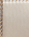 Beige fitted crib sheet on a wooden crib mattress with vertical slats and carpeted flooring underneath.