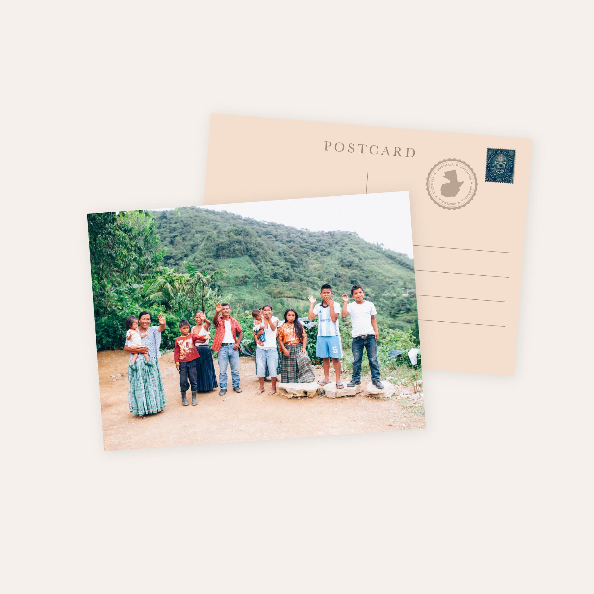 Postcard showing group of people waving outdoors with green hills in the background and beige back with stamp and text "POSTCARD