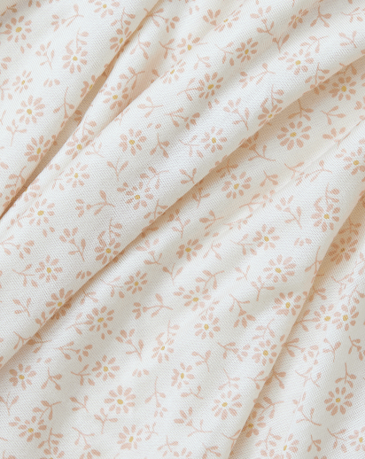 White fabric with small light brown floral and leaf pattern, shown in soft folds.