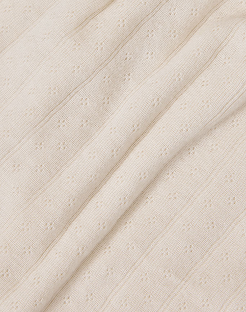 Cream-colored fabric with subtle textured eyelet pattern and fine ribbed stripes.
