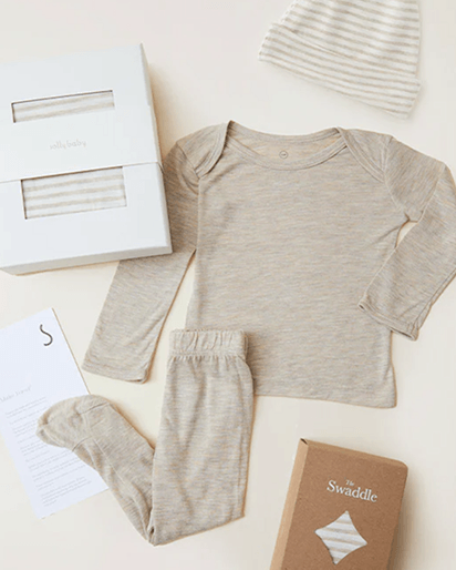 Beige striped baby long sleeve top, pants, socks, and hat set with packaging boxes on light background.