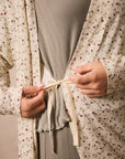 Person wearing a strawberry robe tying it around their waist.