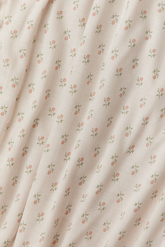 Cream fabric with small pink floral pattern and green stems, soft and lightweight material.