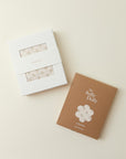 White and brown gift boxes with floral patterned fabric inside branded "sollybaby" and "The Solly Dolly" text on packaging.