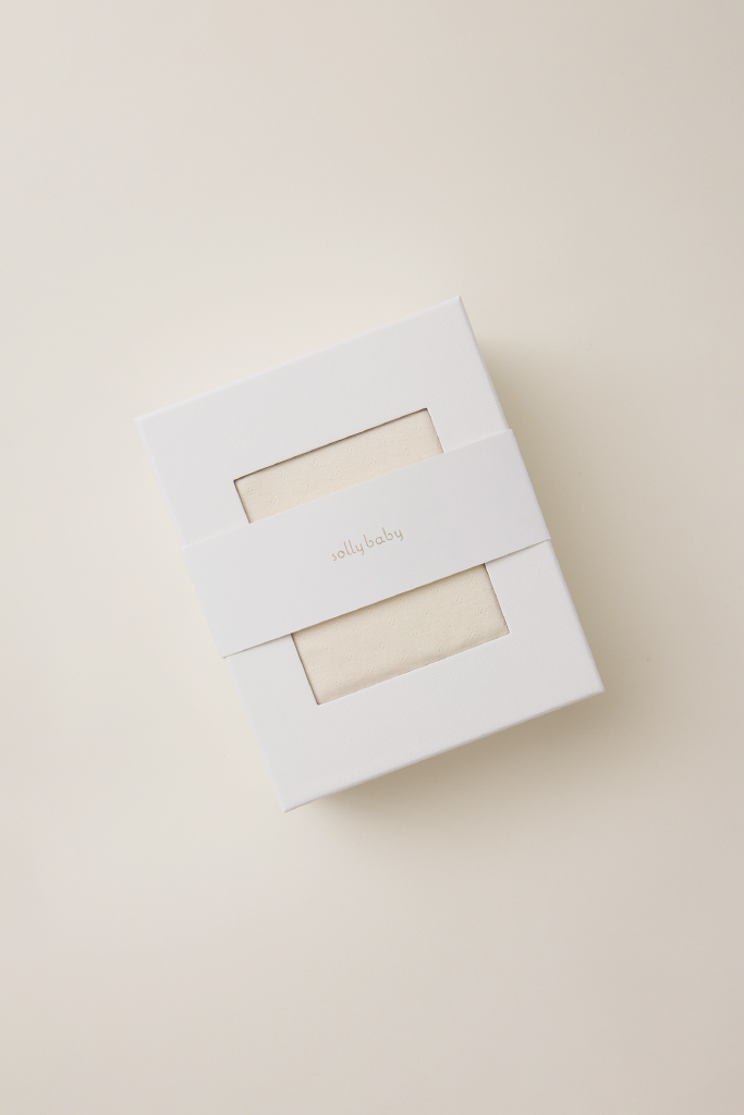 White box with a cream pointelle fabric inside on a beige background