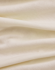Close-up of cream pointelle fabric with a subtle pattern