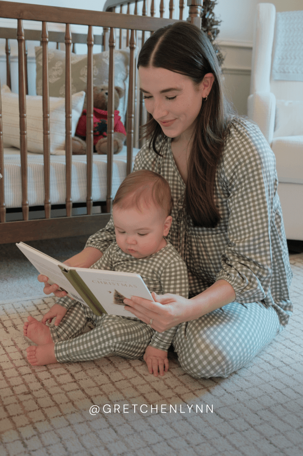 Woman and baby in matching green and white gingham sleep sets reading a book in a nursery. Features the instagram handle @gretchenlynn