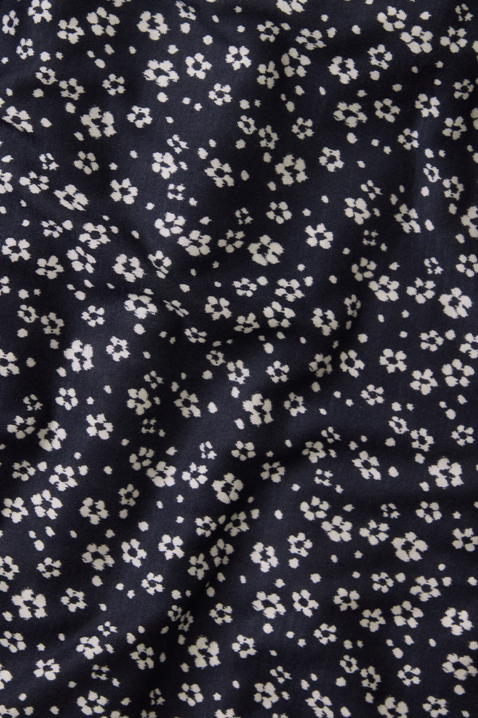 Navy blue fabric with small white ikat floral pattern