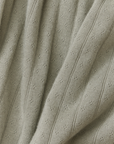 Close-up of textured light green fabric with visible pointelle pattern