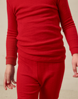 Red long-sleeve pointelle shirt and pants on a neutral background