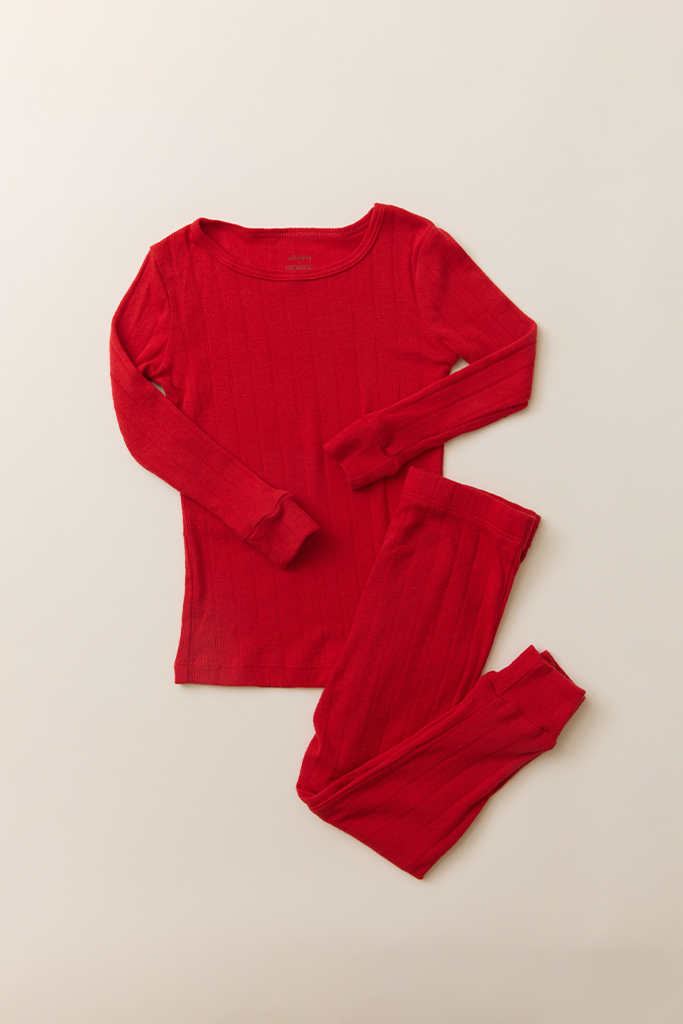 The Toddler Sleep Set in red pointelle, featuring a long-sleeve top and matching leggings laid flat on a neutral background.