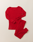 The Toddler Sleep Set in red pointelle, featuring a long-sleeve top and matching leggings laid flat on a neutral background.