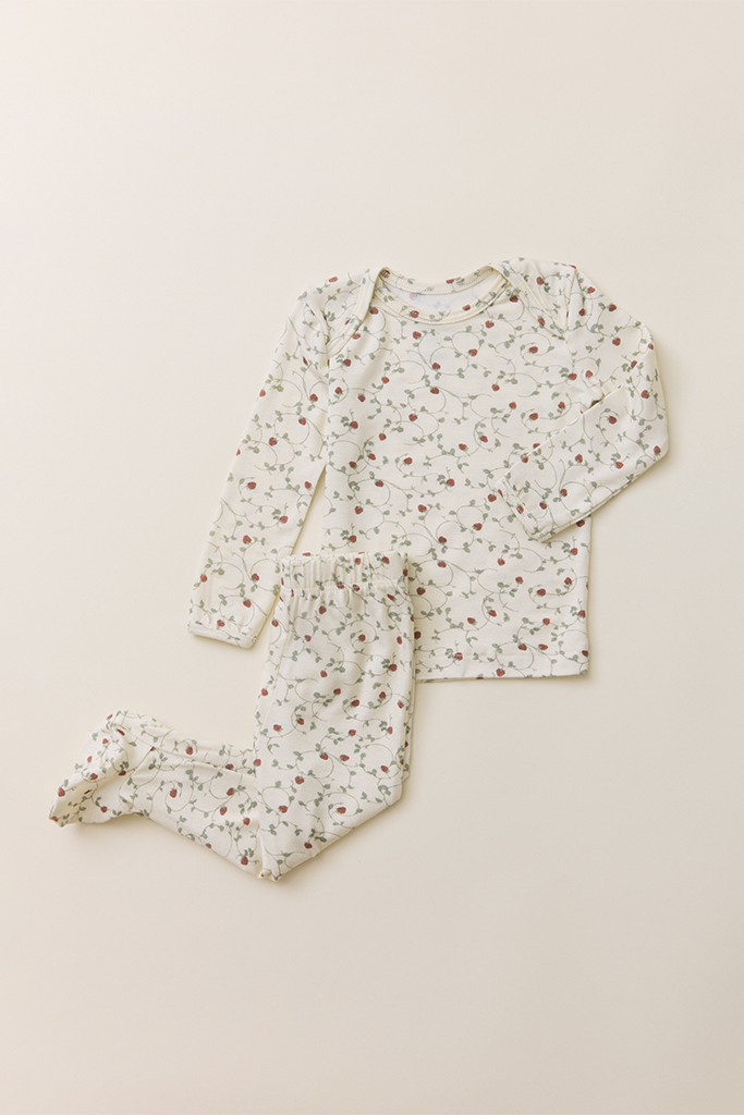 The Baby Sleep Set in a dainty, strawberry vine print, featuring a long-sleeve top and matching footed leggings laid flat on a neutral background.