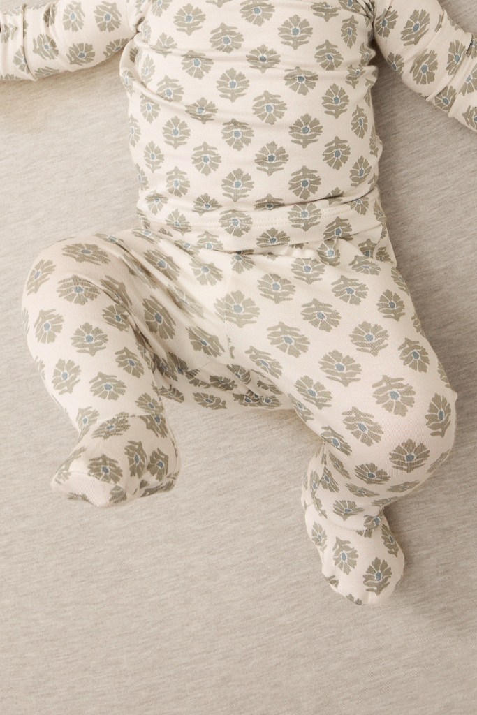 Baby outfit with floral pattern on a neutral background