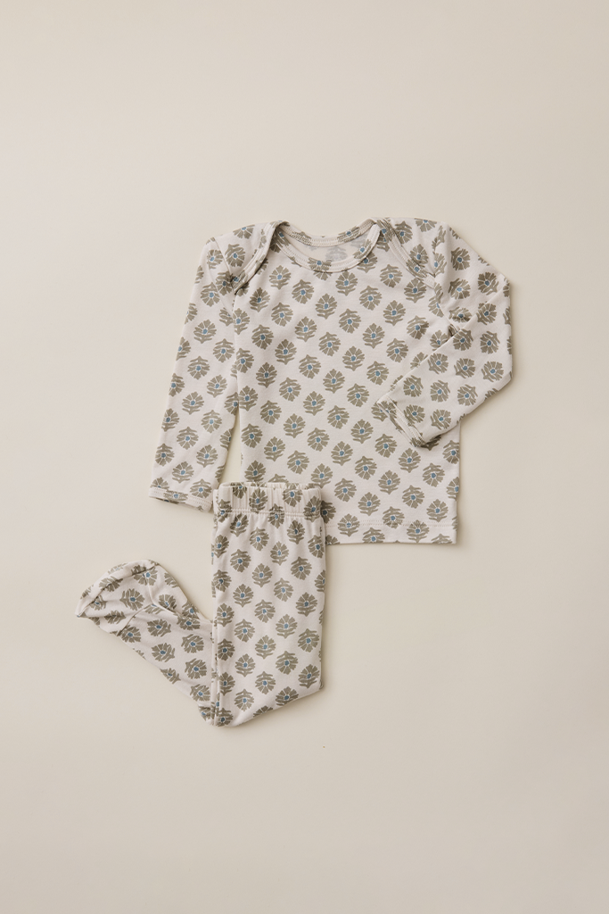 Floral patterned baby outfit on a beige background
