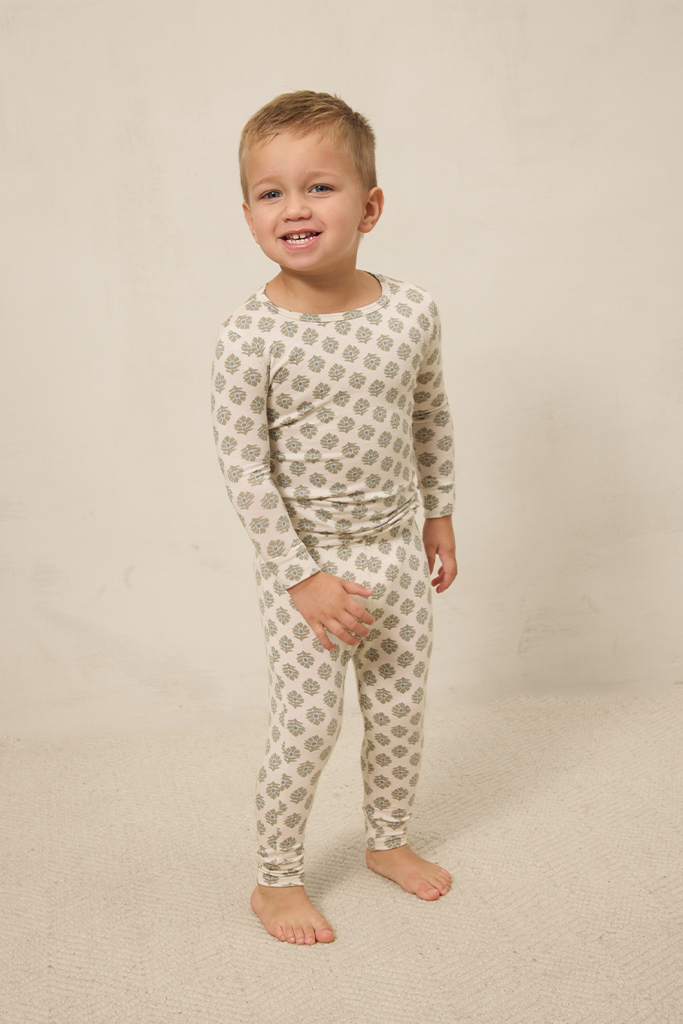 Child wearing a patterned pajama set on a beige background