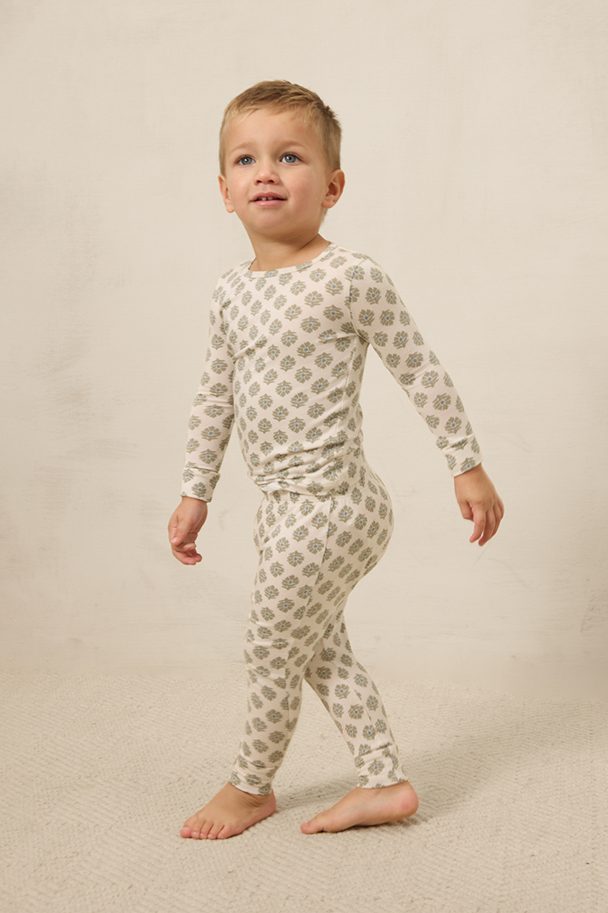 Child wearing a patterned pajama set on a plain background