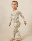 Child wearing a patterned pajama set on a plain background